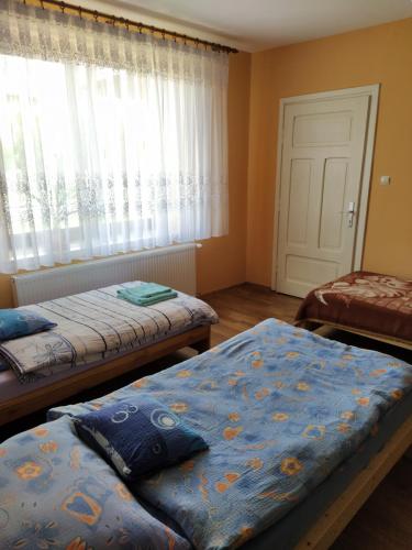 a bedroom with two beds and a window at Pokoje do wynajęcia in Częstochowa