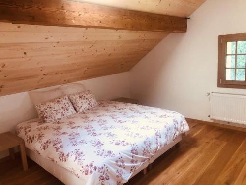 a bedroom with a bed with a wooden ceiling at Chalet Schwendli in Schwarzsee