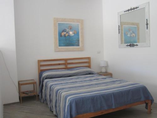 um quarto com uma cama com um cobertor listrado azul em MONOLOCALE SAN PANTALEO em San Pantaleo