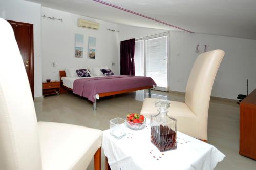 um quarto com uma cama, uma mesa e cadeiras em Apartments Roza em Trogir