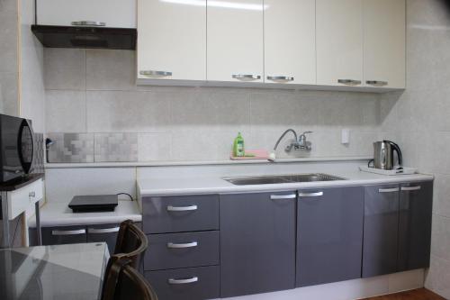 a kitchen with blue cabinets and a sink at Jeju Feel House in Jeju