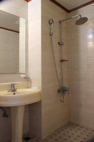 a bathroom with a sink and a shower at Jeju Feel House in Jeju