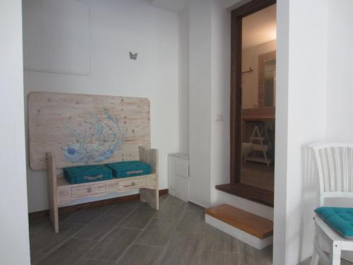 Zimmer mit einer Holzbank und einem Spiegel in der Unterkunft MONOLOCALE SAN PANTALEO in San Pantaleo