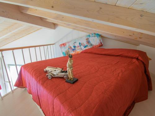 Un dormitorio con una cama roja con un coche de juguete. en Cherubino - stunning lake view with swimming pool en Parzanica