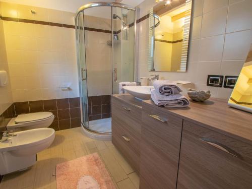 La salle de bains est pourvue de toilettes, d'un lavabo et d'une douche. dans l'établissement Cherubino - stunning lake view with swimming pool, à Parzanica