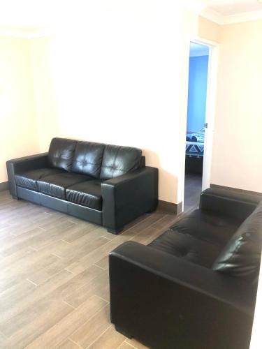 a black leather couch in a living room at Bay Lodge in Denham