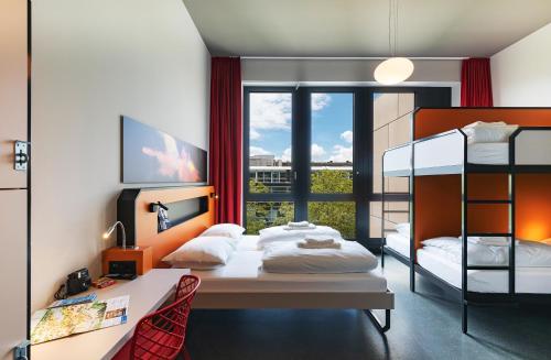 sypialnia z 2 łóżkami piętrowymi i biurkiem w obiekcie MEININGER Hotel Genève Centre Charmilles w Genewie