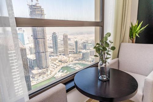 a room with a table and a large window at LiveIn Holiday Homes - JBR in Dubai