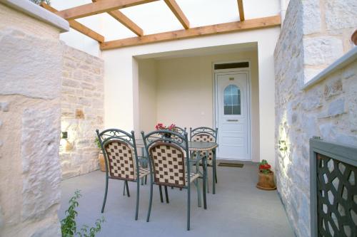 a patio with four chairs and a table with flowers at Kastro Apartments in Panormos Rethymno