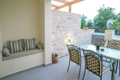 a patio with a table and chairs and a couch at Kastro Apartments in Panormos Rethymno
