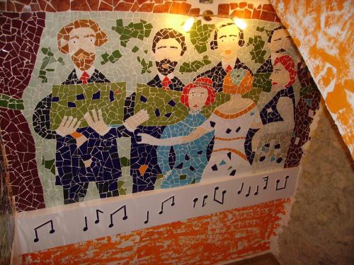 a mosaic of a group of people on a wall at Ca les Barberes in Paúls
