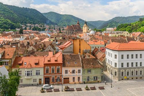 a view of a town with mountains in the background at Hotel Aro Palace in Braşov