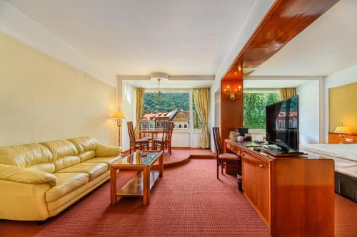 a living room with a couch and a table at Hotel Aro Palace in Braşov