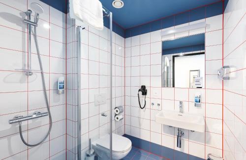 y baño con ducha, aseo y lavamanos. en MEININGER Hotel Genève Centre Charmilles en Ginebra