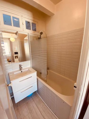 une salle de bain avec un lavabo et une baignoire et un lavabo dans l'établissement studio Newport à 50 m du Marché et calme, à Le Touquet-Paris-Plage