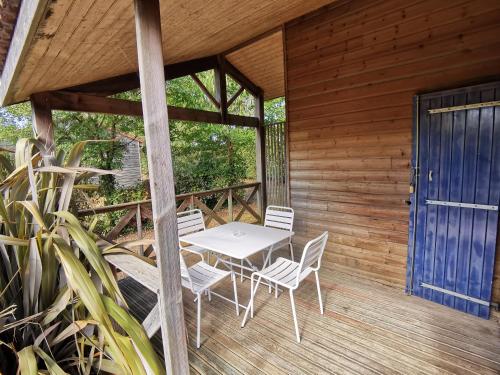 a patio with a table and chairs on a deck at camping de la chagnée in Saint-Aubin-le-Cloud