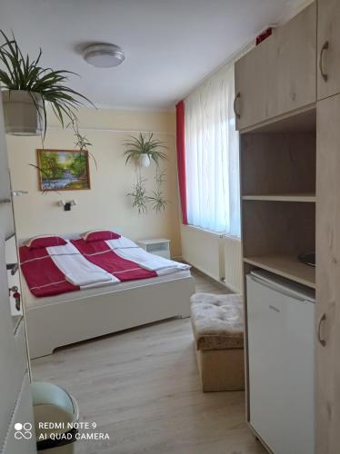a bedroom with a bed with a red blanket at Akác Vendégház in Eger