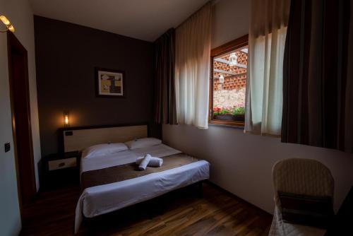 a hotel room with two beds and a window at Hotel Carignano in Lucca