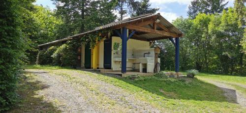 a small building on the side of a dirt road at camping de la chagnée in Saint-Aubin-le-Cloud