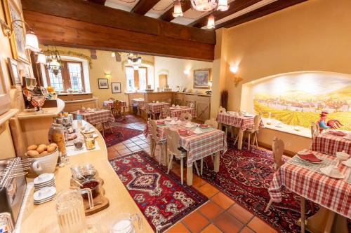 un restaurante con mesas y una gran pintura en la pared en Hotel à l'Oriel, en Riquewihr