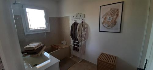 een badkamer met een wastafel, een spiegel en een raam bij LA MAISON DU PONT DU GARD in Vers Pont du Gard