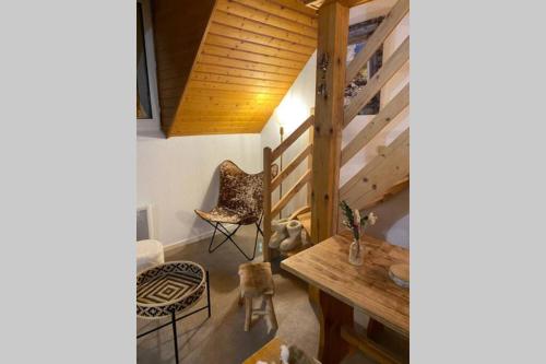 a room with a table and chairs and a wooden ceiling at Appartement T3 Saint Lary-Soulan; Vielle-Aure in Vielle-Aure