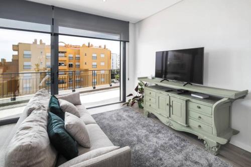 a living room with a couch and a flat screen tv at Apartment Confort 404 in Portimão