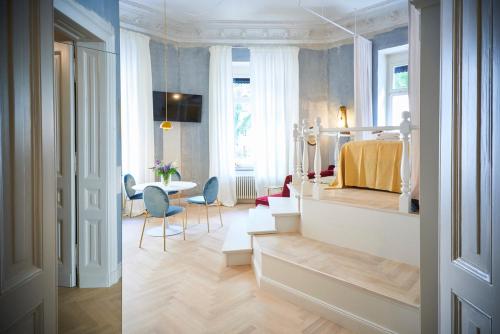 une chambre avec un lit, une table et des chaises dans l'établissement Cora Apartments, à Leipzig