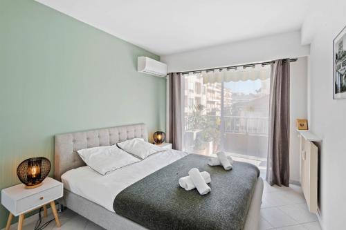 - une chambre avec un lit avec deux croix blanches dans l'établissement Majestic Apartment, à Cannes