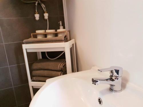 łazienka z umywalką i półką z ręcznikami w obiekcie Eva Home w mieście Roşiori de Vede