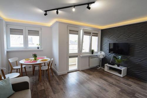 Una sala de estar con una mesa y un televisor. en Apartament Barcelona, en Kielce