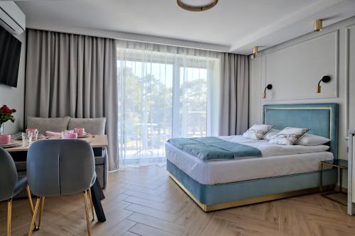 a bedroom with a large bed and a table and chairs at Baltic House in Ustka