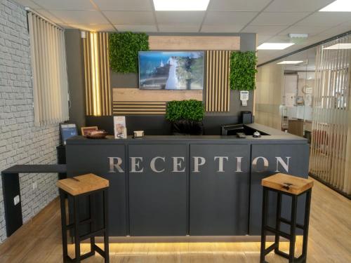 a reception desk in a lobby with two stools at Apart Hotel Rosen in Sofia