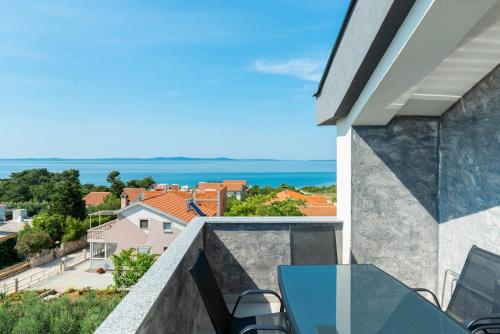 a balcony with a table and chairs and the ocean at Crowonder Luxury Vir- 6 New Apartments for Families with Playground for Kids in Vir