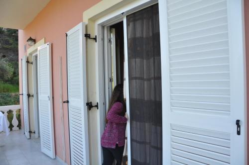 a woman standing in a hallway between two doors at Villa Vasiliki in Vitalades