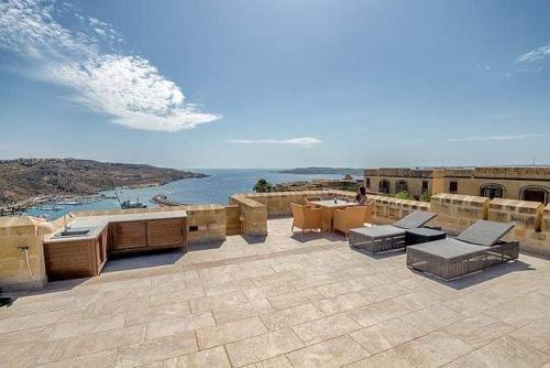 a patio with furniture and a view of the ocean at Fort Chambray Harbor Breeze in Għajnsielem