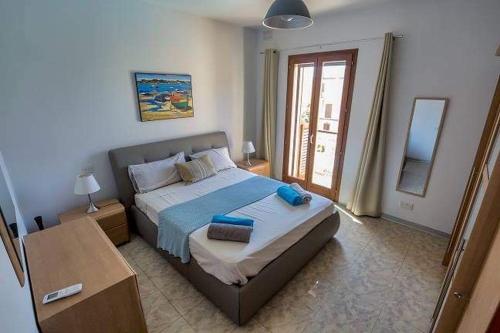 een slaapkamer met een bed met blauwe kussens erop bij Fort Chambray Harbor Breeze in Għajnsielem