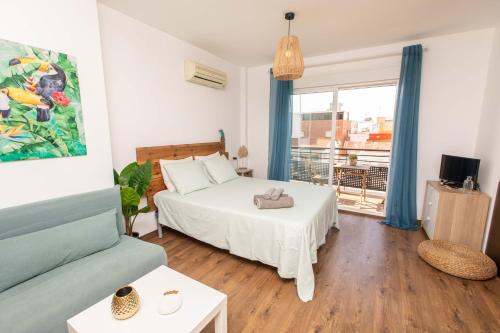 ein Schlafzimmer mit einem Bett und einem Sofa in der Unterkunft Dream by the sea Loft in Málaga