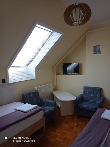 a attic room with a bed and a skylight at Akác Vendégház in Eger