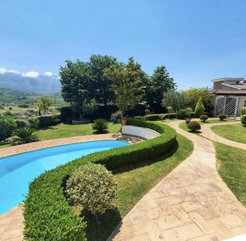 einen Pool in einem Hof mit Hecke in der Unterkunft Vila Elida in Tragjas