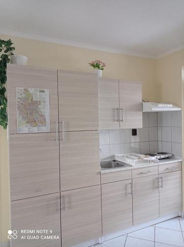 a kitchen with white cabinets and a sink at Akác Vendégház in Eger