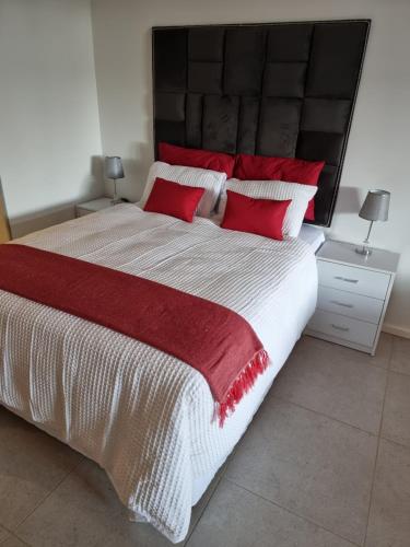 a bedroom with a large bed with red pillows at OCEANDUNE SIBAYA G023 Block D in Umhlanga