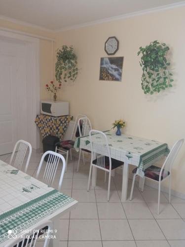 a dining room with a table and chairs and a clock at Akác Vendégház in Eger