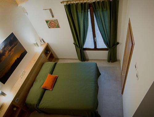 a small bedroom with a green bed and a window at PaeseMio Cervarezza di Bolzoni Maria Graziella in Cervarezza