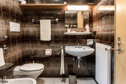 a bathroom with a toilet and a sink at Residence Greymold in Rifiano