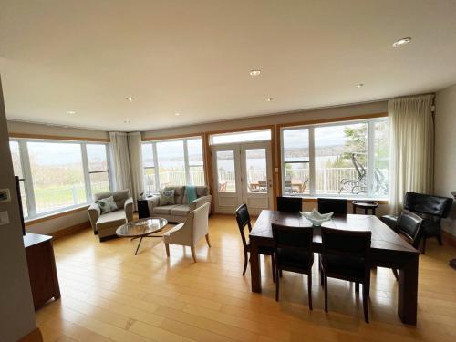 a large living room with a table and chairs at Au Sommet du Lac Magog in Magog-Orford
