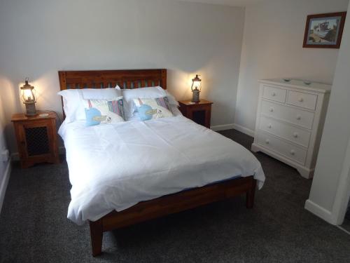een slaapkamer met een groot wit bed en 2 nachtkastjes bij Wayside in Fulmodeston