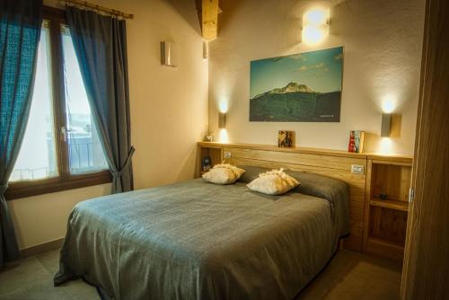 a bedroom with a bed with two pillows on it at PaeseMio Cervarezza di Bolzoni Maria Graziella in Cervarezza