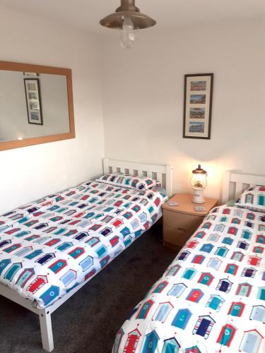 a bedroom with two beds and a table with a lamp at Wayside in Fulmodeston