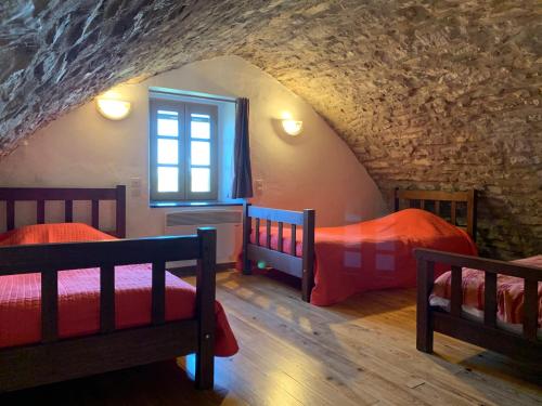 1 dormitorio con 2 camas y ventana en Gîte du Dolmen de l'Hom, en Le Massegros
